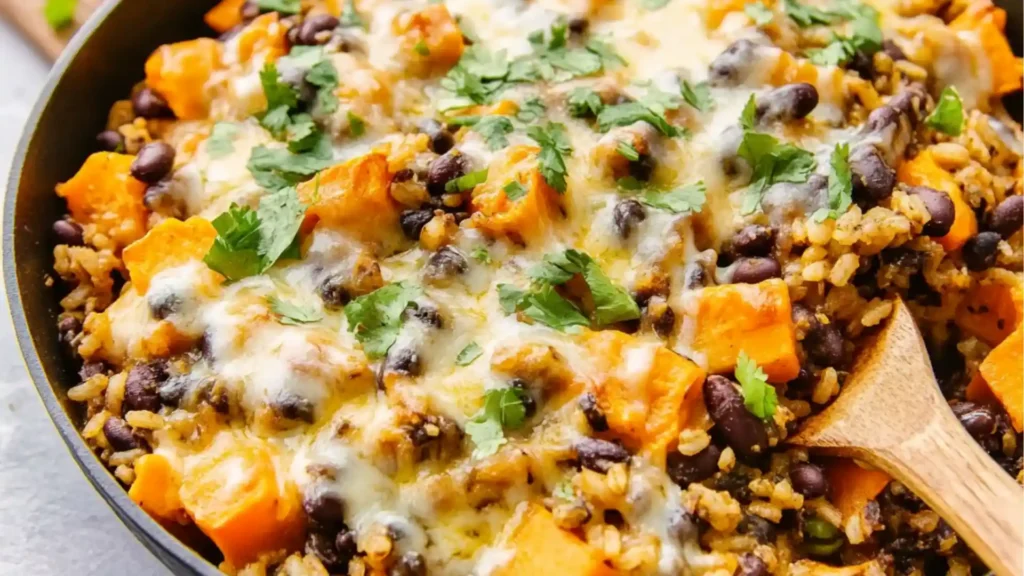 southwest sweet potato black bean and rice skillet with avocado slices on the side