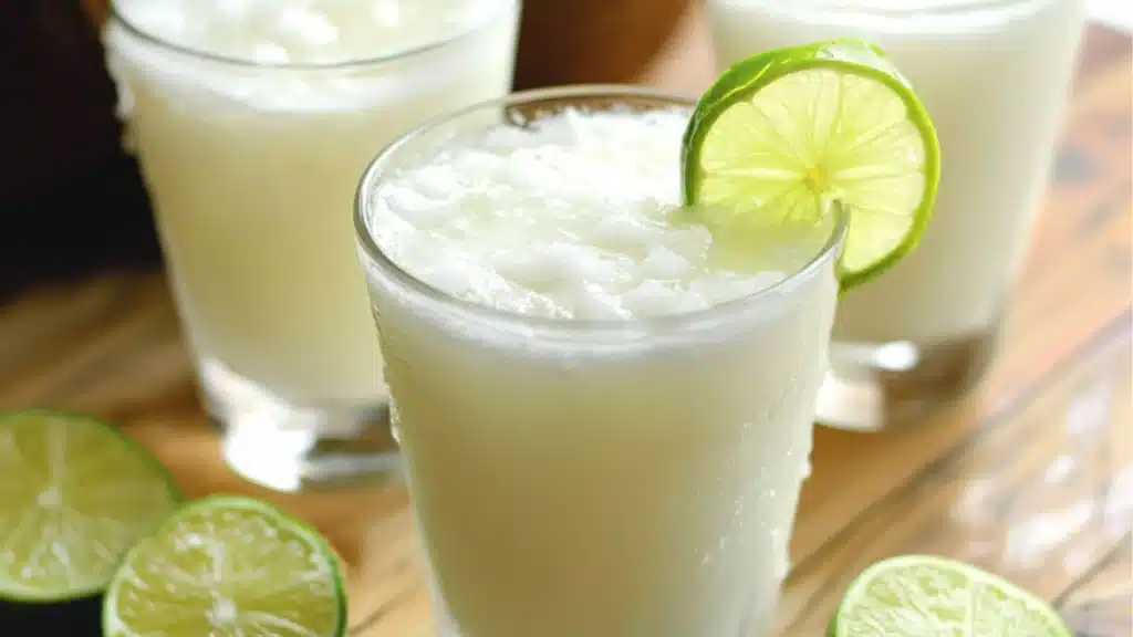 coconut milk is being poured into a glass with the words coconut coolers on it