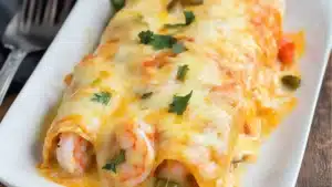 creamy shrimp enchiladas in a white casserole dish with text overlay