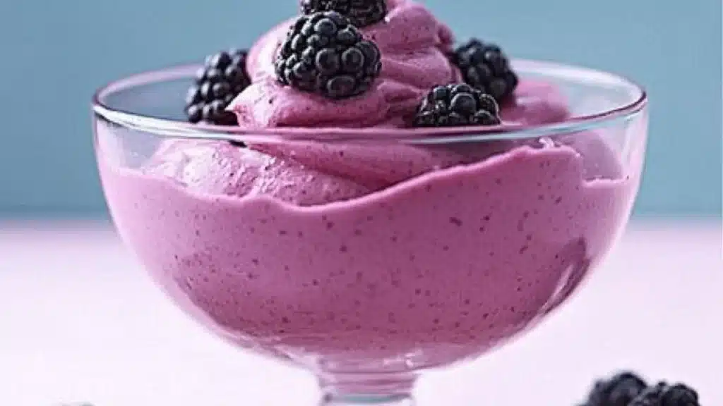 blackberry mousse in a bowl with blackberries on top and the words blackberry mousse above it