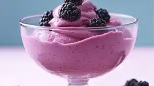 blackberry mousse in a bowl with blackberries on top and the words blackberry mousse above it