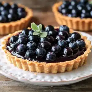 blueberry ganache tarts with fresh blueberries on the side and text overlay