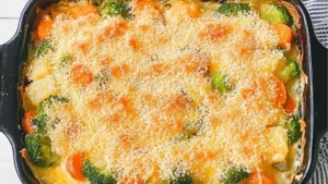 cheddar vegetable gratin in a white casserole dish