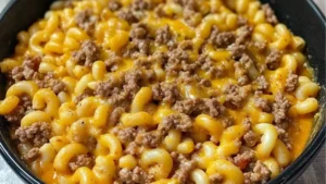 homemade hamburger helper recipe with macaroni and cheese in a skillet on a spoon