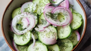 cucumber dill salad with fresh herbs in a bowl and on the side