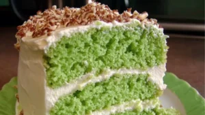 there is a square piece of green cake on the plate and it has frosting