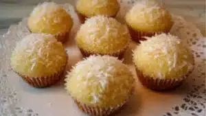 some coconut muffins sitting on top of a metal pan with the words portuguese coconut cakes above them