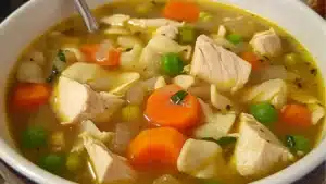 creamy mary mee chicken soup in a bowl with bread on the side and text overlay that reads tuscan style mouth - watering creamy mary mee chicken soup