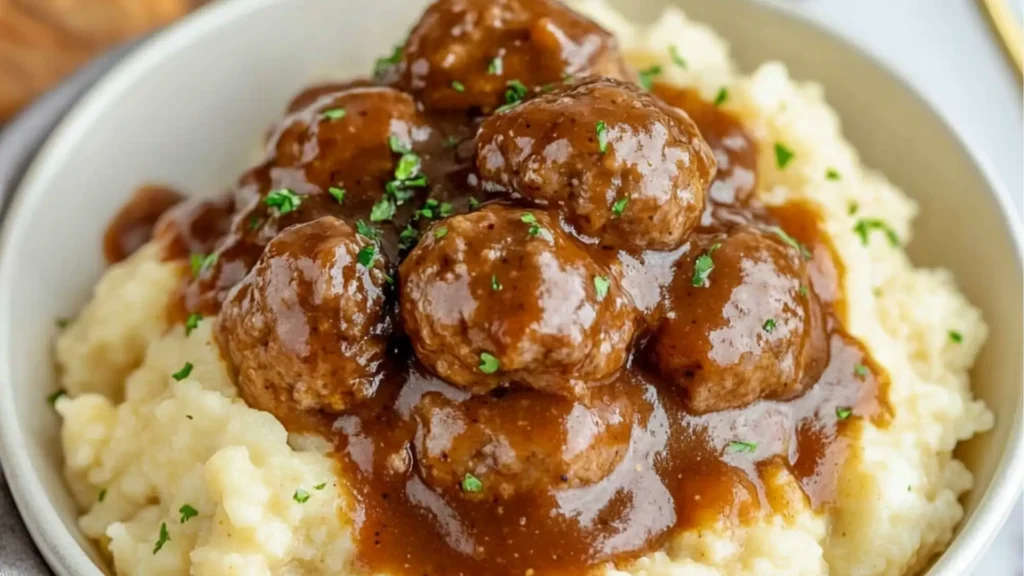 crockpot salisbury steak meatballs with gravy on top and potatoes in the middle