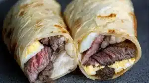 an egg wrap is cut in half and placed on a cutting board with the words, carnivor steak egg wrap