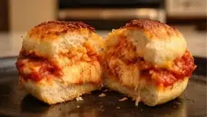 halloween chicken parm sliders on a plate with olives and toothpicks
