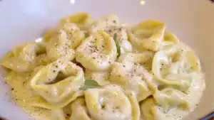 creamy tortellini with spinach in a skillet and text overlay that reads easy creamy tortellini with spinach