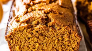 a loaf of vanilla pudding pumpkin bread on top of a cutting board with the words, vanilla pudding pumpkin bread