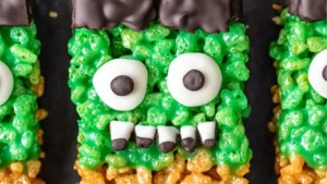 halloween rice krispy treats with green frosting and black sprinkles on them