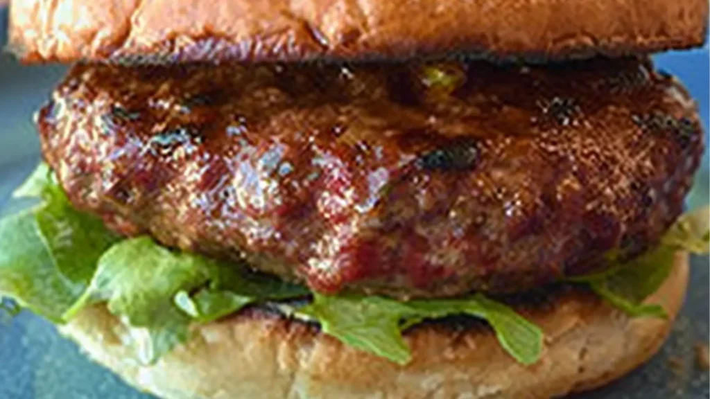 grilled lamb burgers with feta are stacked on top of each other and the title reads grilled lamb burgers with feta