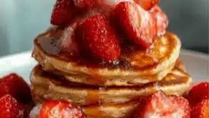 Strawberries and cream low calorie high protein pancake stack with strawberry white chocolate chip and whipped cream