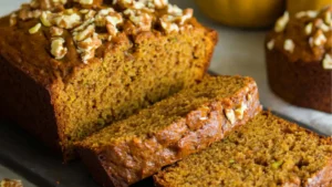 sliced pumpkin zucchini bread on a cutting board with the words, pumpkin zucchini bread
