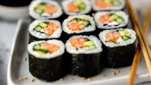 sushi rolls on a plate with cucumber and lime