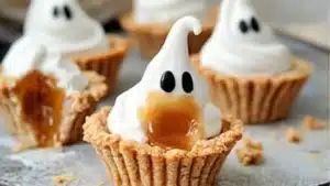 mini caramel meringue ghost tarts with whipped cream on top