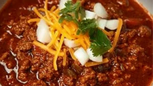 a white bowl filled with chili and topped with cilantro