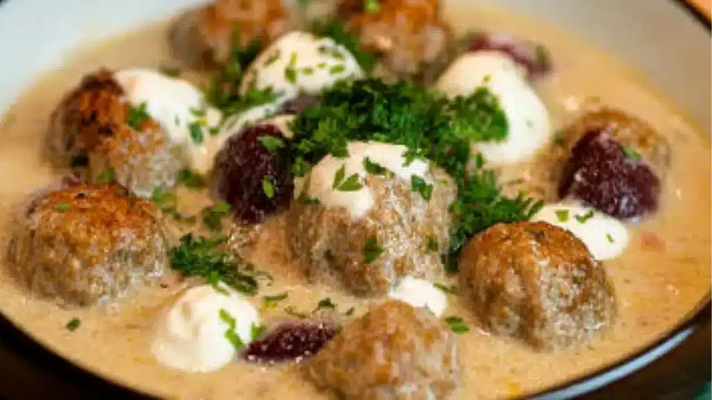 a close up of a bowl of soup with meatballs