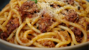 a plate of pasta with meat and parsley on top, in front of the words greek pheasant pasta
