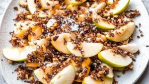 apple nachos on a white plate with caramel drizzle