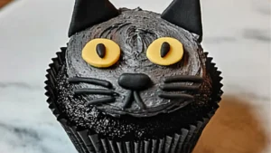 A photo of a Black Cat Keto Cupcakes which is a type of Keto Halloween Desserts