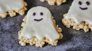 some cookies with chocolate chips in the shape of ghost faces and eyes are on a black surface