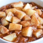 bowl of apple pie dip with cinnamon sugar chips and a sheet pan of baked cinnamon sugar tortilla chips.