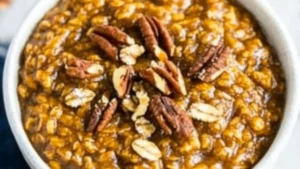 pumpkin pie oatmeal in a white bowl with pecans on the side