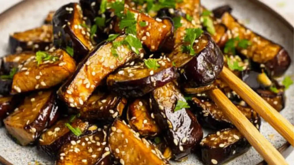 grilled eggplant on two plates with the title overlay reads, the best irresistiblely garlic eggplant