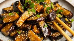 grilled eggplant on two plates with the title overlay reads, the best irresistiblely garlic eggplant