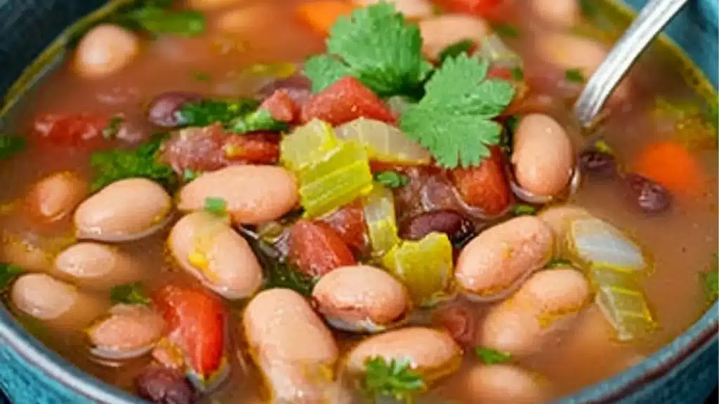 mexican pinto beans soup in a skillet with the title text overlay reads easy