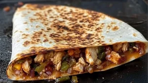 two grilled quesadillas on a black plate with text overlay reading blackstone hot honey bbq chicken quesadillas