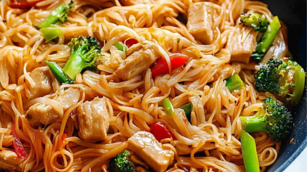 easy rice noodle stir - fry in a skillet with text overlay that reads easy rice noodle stir - fry