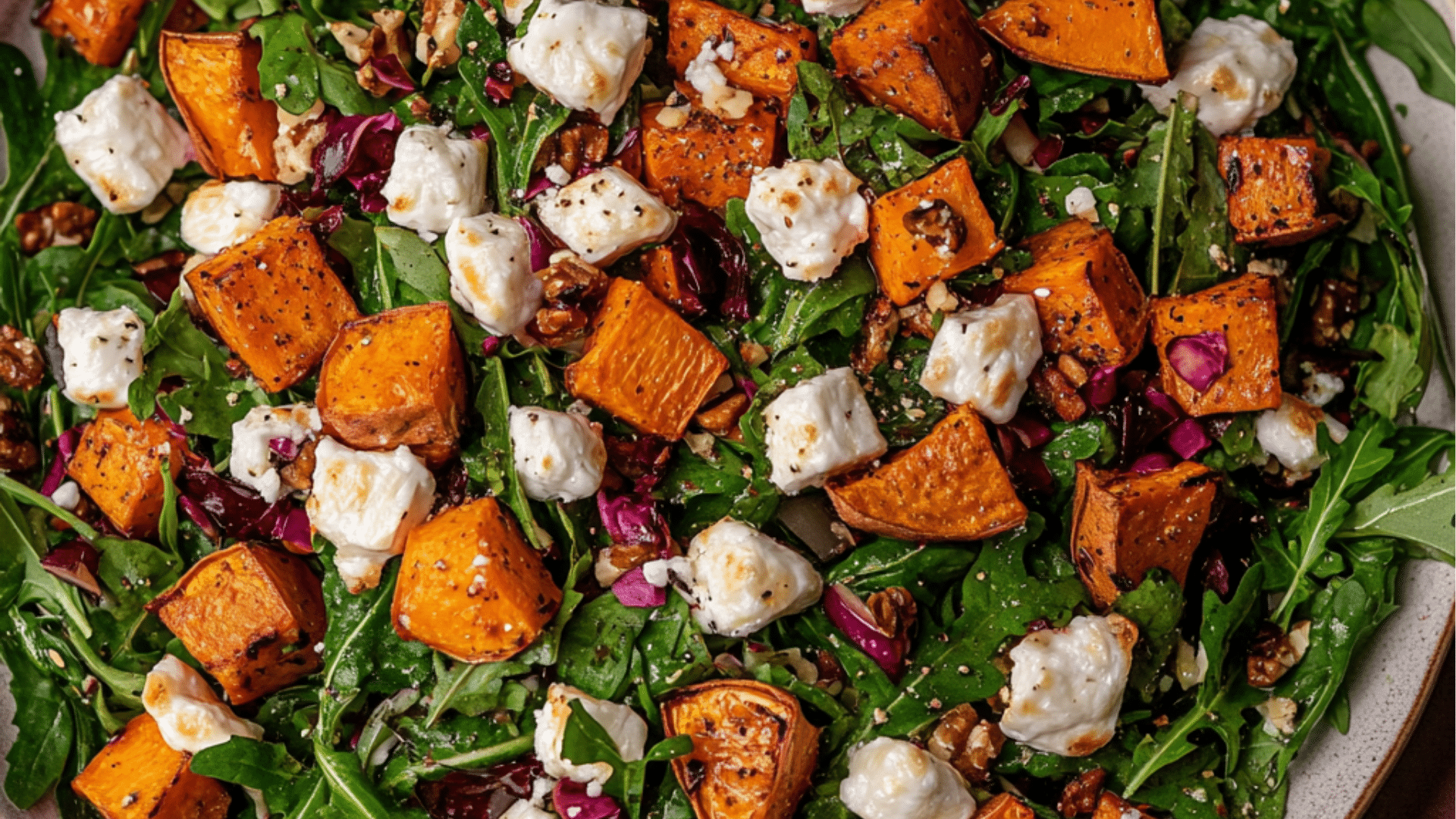 a white plate topped with greens and sweet potato salad