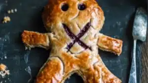 there is a cookie shaped like a teddy bear with words voodoo pies on it