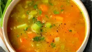 easy carrot and celery soup in a blue bowl on a checkered table cloth