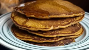 a stack of pancakes with syrup being poured on top and the words, how to make gingerbread pancakes