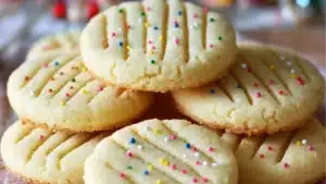 easy whipped shortbread cookies recipe with white frosting and colorful sprinkles