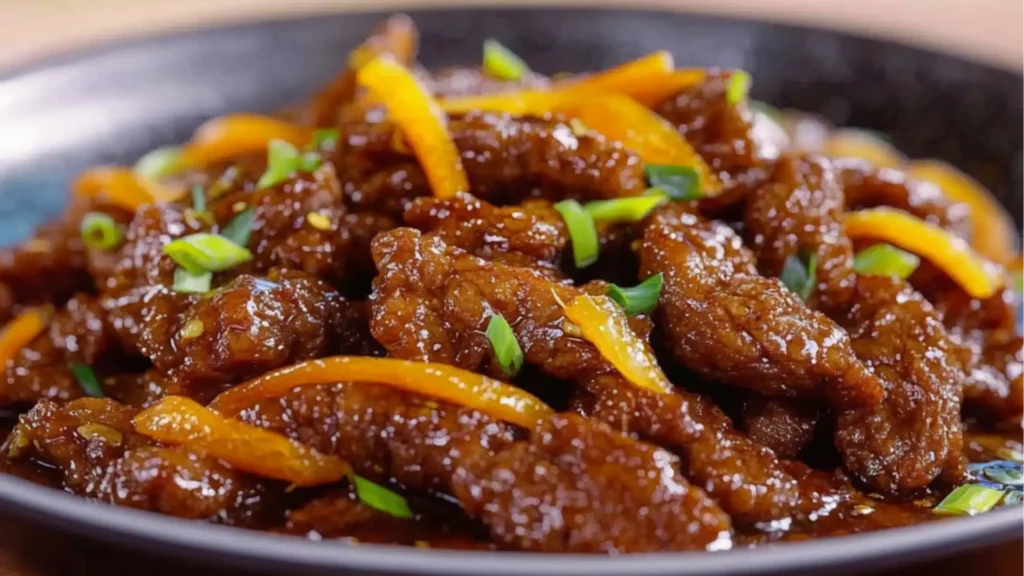 an orange beef and rice dish with the words crispy beef in orange sauce