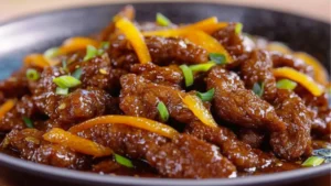 an orange beef and rice dish with the words crispy beef in orange sauce