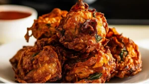 potato fritters with sour cream and parsley on parchment paper next to a bowl of ranch dressing