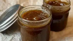 the best easy holiday gift vanilla spiced pear butter is in a glass jar with a spoon