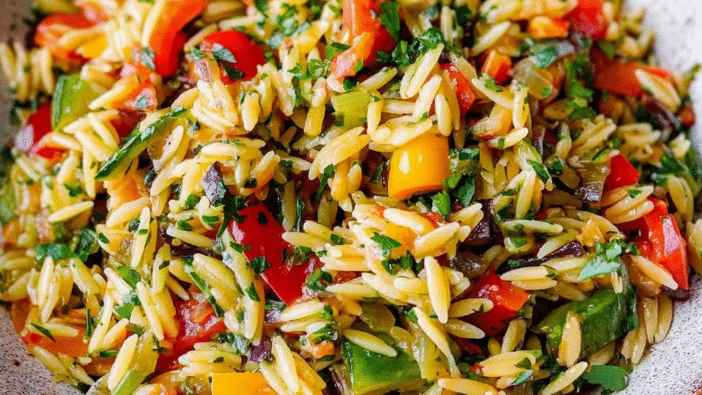 Flavorful Veggie Orzo: A Quick and Healthy One-Pan Meal Looking for a comforting, satisfying, and healthy dish that comes together in under 30 minutes? This Veggie Orzo recipe is your go-to solution. It's packed with fresh vegetables, tender orzo pasta, and a light seasoning that makes it a perfect addition to your weeknight dinner rotation or quick lunch meal prep. Whether you're a busy parent, college student, or simply someone trying to eat more plant-based meals, this dish is for you. It's easy, versatile, affordable, and totally customizable. Plus, if you're into healthy eating without sacrificing taste, this recipe checks all the boxes. Why You'll Love This Easy Veggie Orzo Recipe This dish is not just another pasta recipe. It’s: Nutritious: Loaded with fiber, vitamins, and antioxidants from the vegetables Quick and Simple: Ready in about 25 minutes Customizable: Use any veggies you have in the fridge Family-Friendly: Loved by kids and adults alike Great for Meal Prep: Stores well and tastes great reheated If you love wholesome, satisfying meals like this, you might also enjoy our Vegetarian Pasta Primavera or this protein-packed Cottage Cheese Egg Salad . Ingredients for Veggie Orzo Here’s what you’ll need to make this delicious one-pan veggie orzo: 1 tbsp olive oil 1/2 yellow onion, diced 1 garlic clove, minced 1/2 red bell pepper, diced 1/2 zucchini, diced 1/2 cup cherry tomatoes, halved 1/2 cup frozen peas 3/4 cup dry orzo pasta 1 1/2 cups vegetable broth 1/2 tsp Italian seasoning Salt and pepper, to taste 1 tbsp freshly grated Parmesan cheese (optional) Optional garnish: fresh basil, lemon zest, or chili flakes Kitchen Equipment You'll Need To make this easy vegetable orzo, you’ll only need a few basic kitchen tools: Large non-stick skillet or sauté pan Wooden spoon or silicone spatula Cutting board and knife Measuring cups and spoons Cheese grater (optional for parmesan) How to Make Veggie Orzo: Step-by-Step Step 1: Sauté Aromatics Heat olive oil in a large skillet over medium heat. Add diced onion and sauté for 2–3 minutes until translucent. Stir in the minced garlic and cook for another minute until fragrant. Step 2: Add Veggies Toss in the red bell pepper and zucchini. Cook for 4–5 minutes until slightly softened. Add cherry tomatoes and peas, stirring everything together. Step 3: Add Orzo and Simmer Pour in the dry orzo and stir to coat with the veggies. Add the vegetable broth, Italian seasoning, salt, and pepper. Bring the mixture to a boil, then reduce heat and simmer uncovered for 10–12 minutes, stirring occasionally, until orzo is tender and liquid is mostly absorbed. Step 4: Finish and Serve Once the orzo is cooked, remove from heat and stir in freshly grated Parmesan if using. Adjust salt and pepper to taste. Serve warm, garnished with basil or lemon zest for a burst of freshness. Looking for more easy veggie-forward recipes? Try our Roasted Vegetable Quinoa Bowl or this comforting Vegetable Casserole . Tips for Perfect Veggie Orzo Every Time Cut veggies evenly so they cook at the same rate. Stir orzo often during cooking to prevent sticking. Use low-sodium broth to control salt levels. Add protein like chickpeas or tofu for a more filling meal. Brighten it up with a squeeze of lemon before serving. Common Mistakes to Avoid Overcooking the orzo: It can get mushy quickly, so keep an eye on it. Using too much liquid: Stick to the recommended broth measurement to avoid a watery dish. Skipping seasoning: Italian seasoning brings it all together—don’t leave it out. Tasty Variations and Add-ins This is one of those healthy orzo recipes that can be customized easily. Try these ideas: Add leafy greens: Stir in spinach or kale at the end. Make it creamy: Add a splash of milk or a spoonful of cream cheese. Spice it up: Use red chili flakes or a spoon of harissa paste. Use roasted vegetables for a deeper flavor, like in our Garlic Herb Roasted Potatoes, Carrots, and Zucchini . Serving and Presentation Tips Serve with a lemon wedge and a sprinkle of parmesan on top Garnish with chopped parsley or fresh basil for a fresh, herby touch Pair it with garlic bread or a Cheddar Bay Biscuit For a hearty meal, serve this veggie orzo alongside a light soup like this Creamy Mushroom Soup or a protein-packed option like our High Protein Steak and Shrimp Stir Fry . How to Store and Reheat Veggie Orzo Store leftovers in an airtight container in the fridge for up to 4 days. Reheat in a microwave or pan over low heat, adding a splash of broth or water to loosen the texture. Is This Good for Meal Prep? Absolutely! Veggie orzo holds up well in the fridge and makes a great lunchbox meal. For best results: Let it cool before storing Divide into individual containers Store a lemon wedge or extra parmesan separately Similar Recipes You May Like Healthy Veggie Egg Scramble Cucumber Dill Salad Mediterranean Veggie Sandwich Garlic Butter Corn with Melty Cheese FAQs About Veggie Orzo Can I use other pasta instead of orzo? Yes! You can substitute couscous, ditalini, or even small elbow pasta—just adjust the liquid as needed. Is this recipe vegan? It can be! Just skip the parmesan or use a vegan alternative. Can I freeze veggie orzo? It's best enjoyed fresh, but you can freeze it for up to 1 month. Reheat gently to avoid mushiness. Final Thoughts on Veggie Orzo This veggie orzo recipe is a must-have in your meal prep routine or weeknight dinner playbook. It's simple, flexible, nutritious, and incredibly flavorful. Whether you're cooking for one or feeding a family, it brings convenience and comfort to the table without sacrificing health. If you loved this recipe, share it with your friends or family! Don’t forget to subscribe to our blog for more easy, healthy meals delivered right to your inbox.