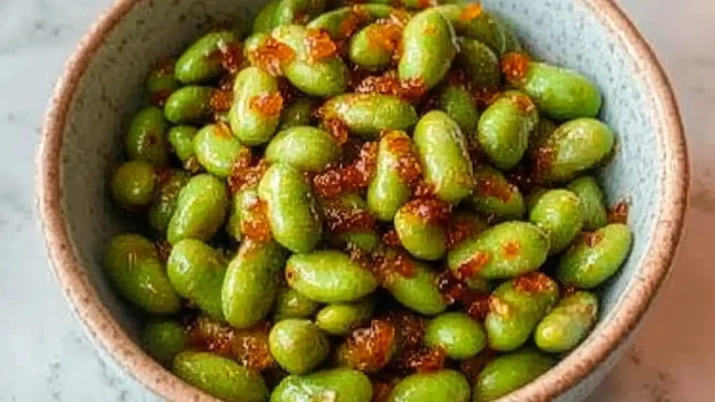 garlic edamame in a bowl with sesame seeds on top and the words easy 30 minute 10 minute garlic edamame