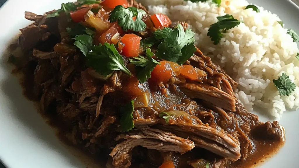 Plate with Carne Desmechada, or Colombian Shredded Beef on a white plate with rice and plantains