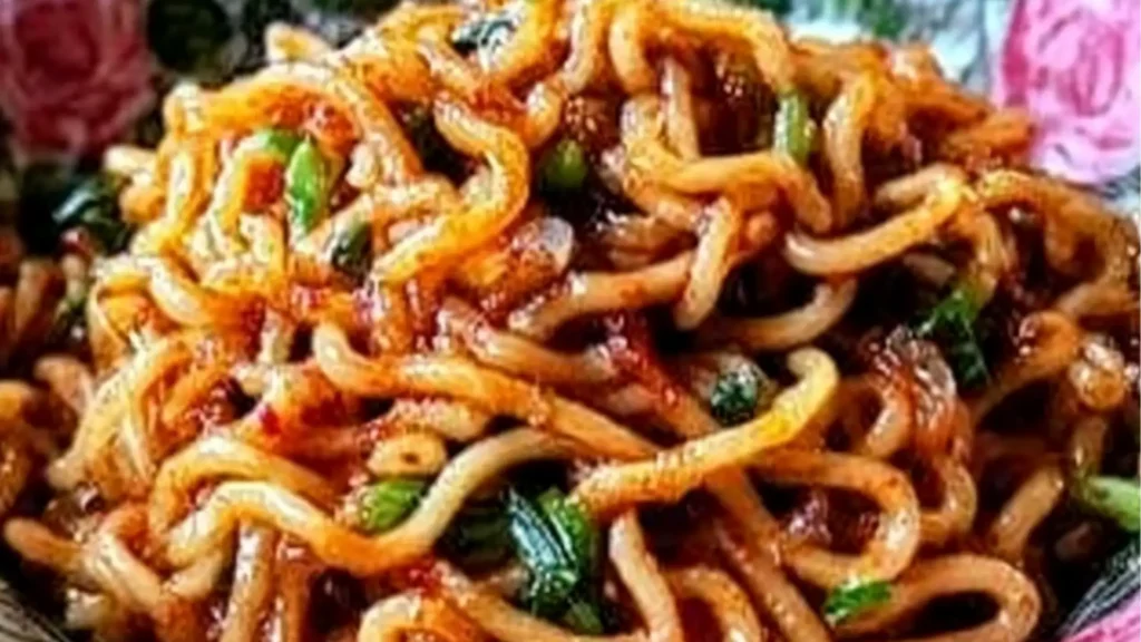 a white plate topped with noodles on top of a wooden table