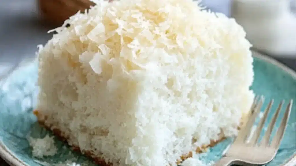 a piece of coconut milk cake on a plate with a fork